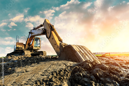 Excavator work on construction site at sunset