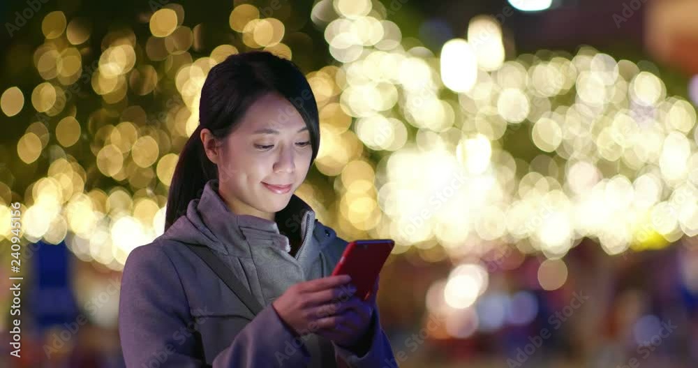 Woman use of mobile phone over Christmas decoration Woman use of mobile phone over Christmas decoration