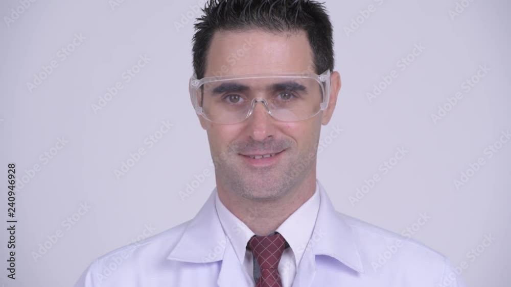 Face of happy handsome man doctor smiling and wearing protective glasses Face of happy handsome man doctor smiling and wearing protective glasses
