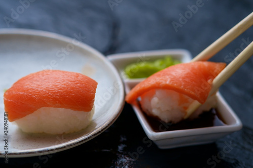 Dipping a salmon sushi in the soy sauce