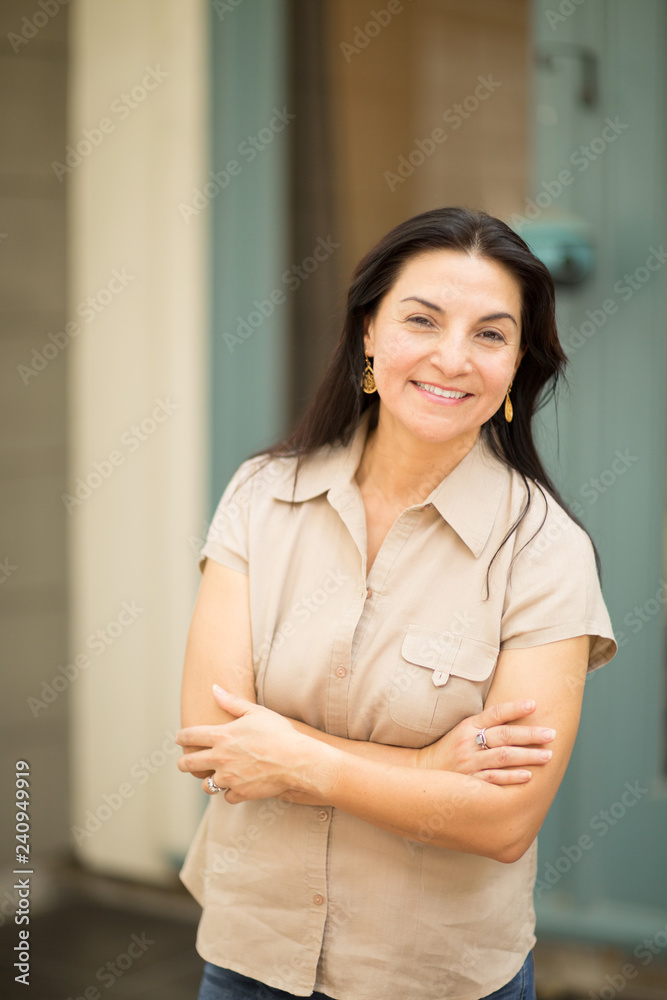Happy Hispanic woman smiling and standing outside. Happy Hispanic woman smiling and standing outside.