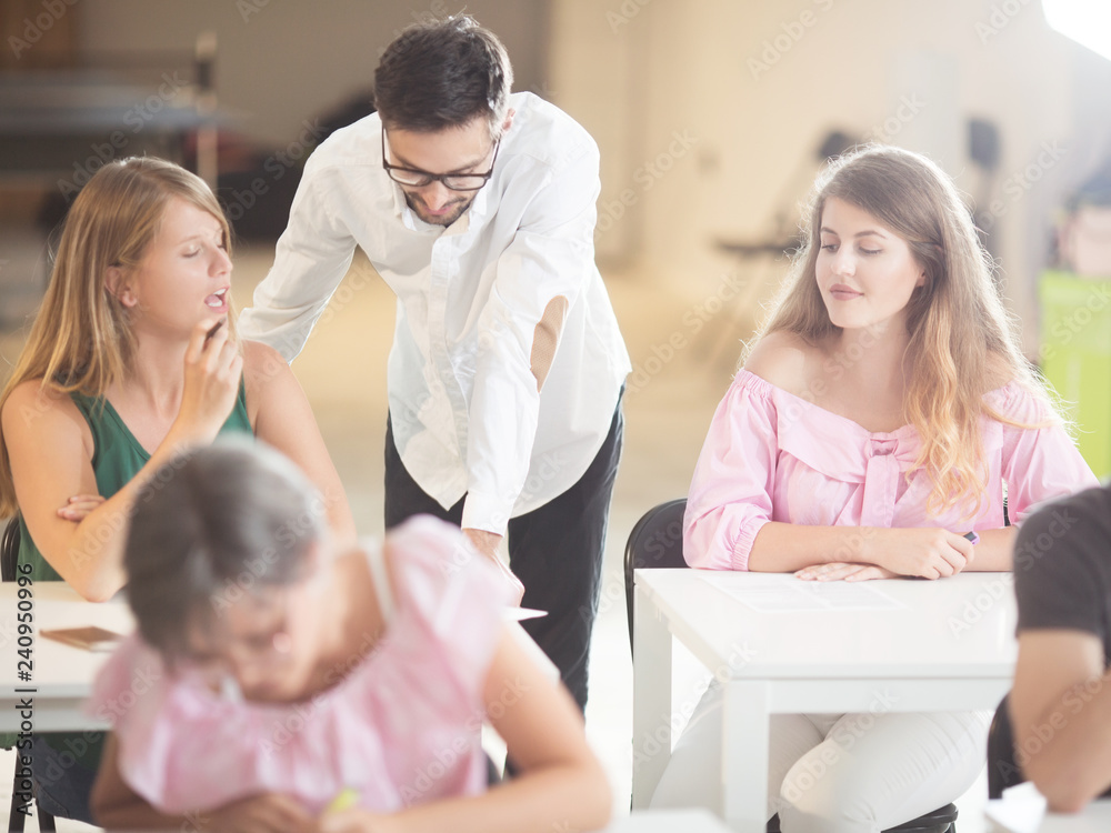 Young students and professor having discusion in classroom Young students and professor having discusion in classroom
