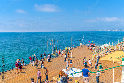 Famous Pier in Santa Monica with tourists, a suburb of Los Angeles. © BRIAN_KINNEY