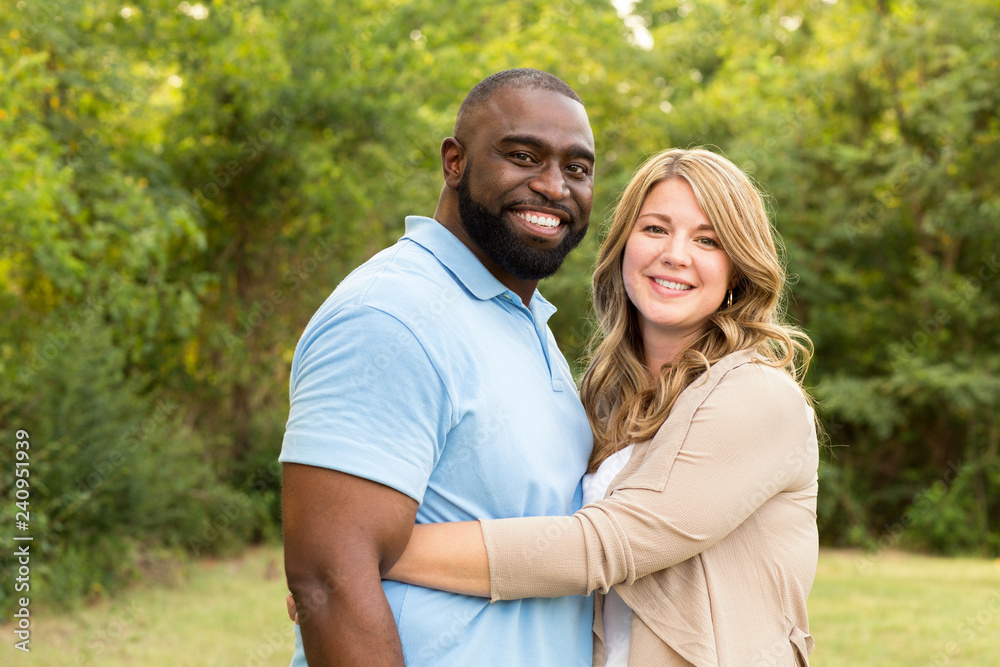 Loving mixed race couple hugging and laughing. Loving mixed race couple hugging and laughing.