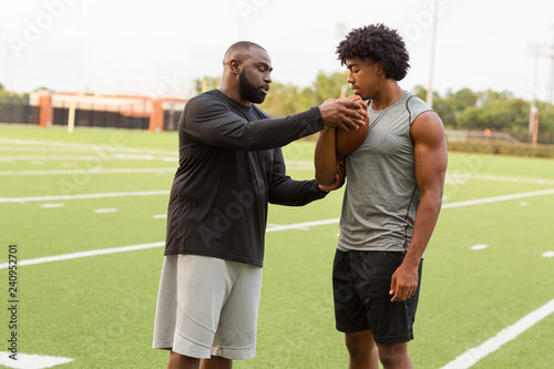 Canvas Print American Football coach training a young athlete.