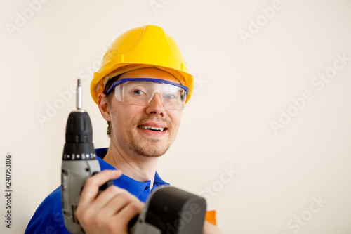 Photo of men with drill and in yellow helmet