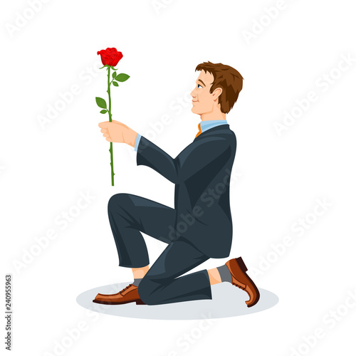 Man is kneeling with a flower in his hand. View from the side
