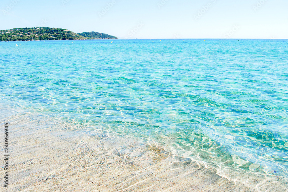 Beautiful and clear white sand beach with background mediterraniean blue sea  and soft light blue sky, hill side and tourist relax on ramatuelle beach,  sout of france. Stock Photo | Adobe Stock