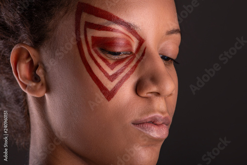 Studio shot of the young woman of the mulatta with abstract make up, macro