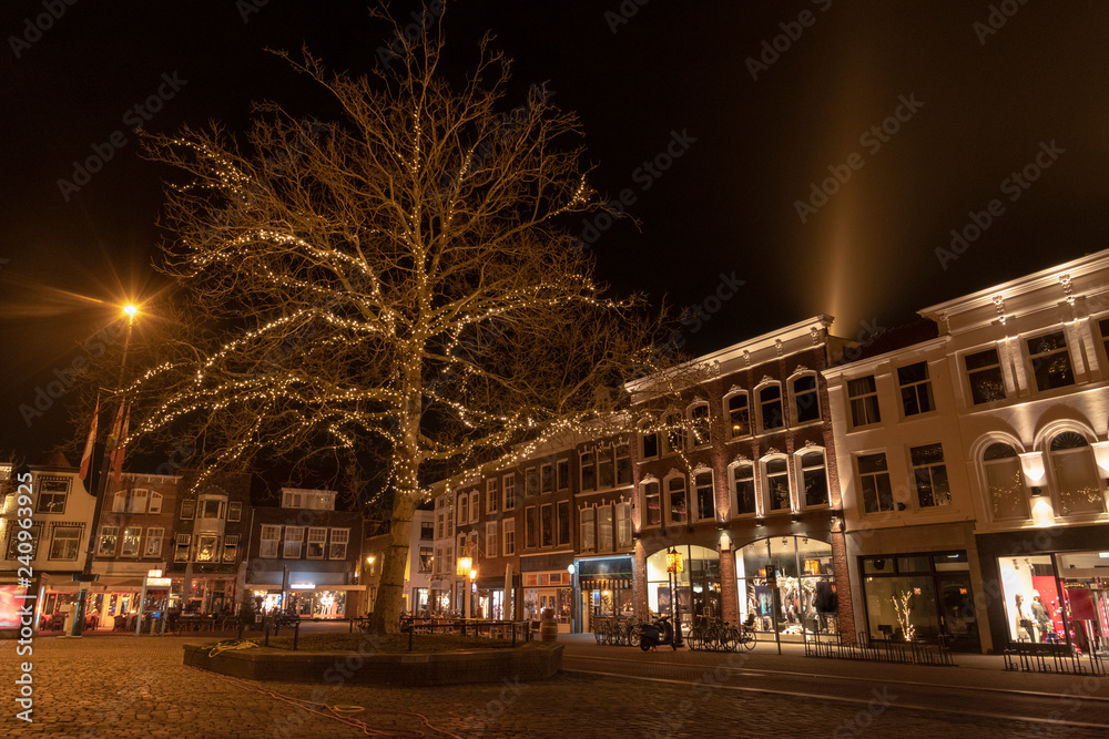 The Gouda market in the evening with a lighted tree and houses with old facades. The Netherlands, Europe.