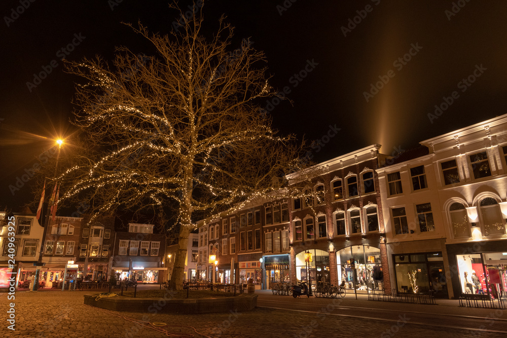 The Gouda market in the evening with a lighted tree and houses with old facades. The Netherlands, Europe. The Gouda market in the evening with a lighted tree and houses with old facades. The Netherlands, Europe.