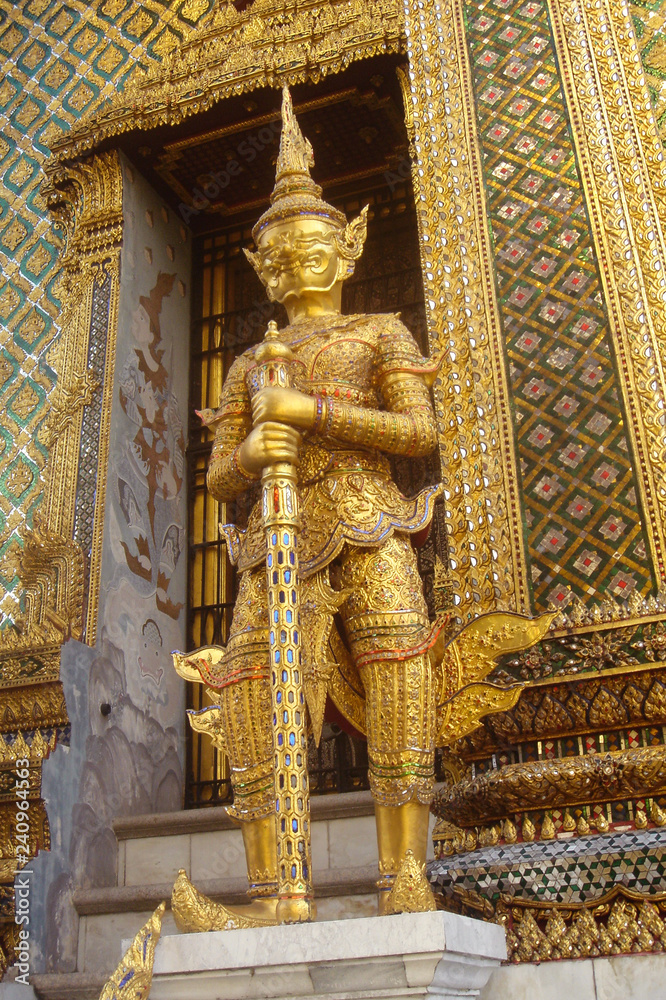 Golden statue of ancient guard in Wat Phra Keao, The Grand Palace, Bangkok, Thailand. Outdoors, copy space.