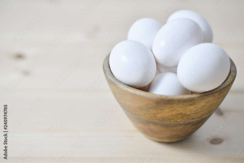 white eggs on wooden plate on wooden background , copy space white eggs on wooden plate on wooden background , copy space