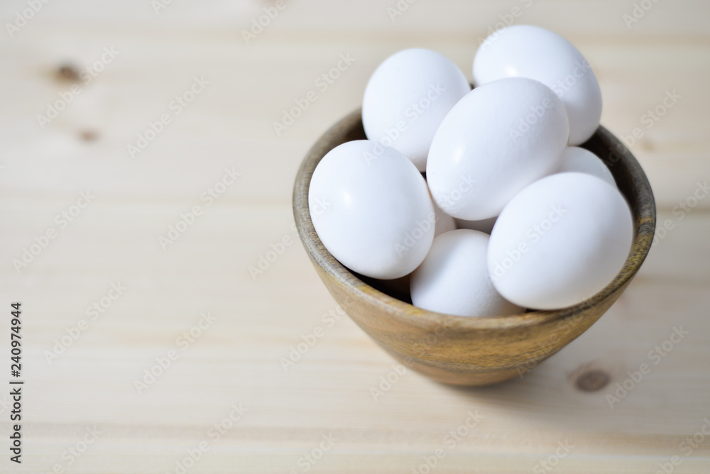 white eggs on wooden plate on wooden background , copy space white eggs on wooden plate on wooden background , copy space