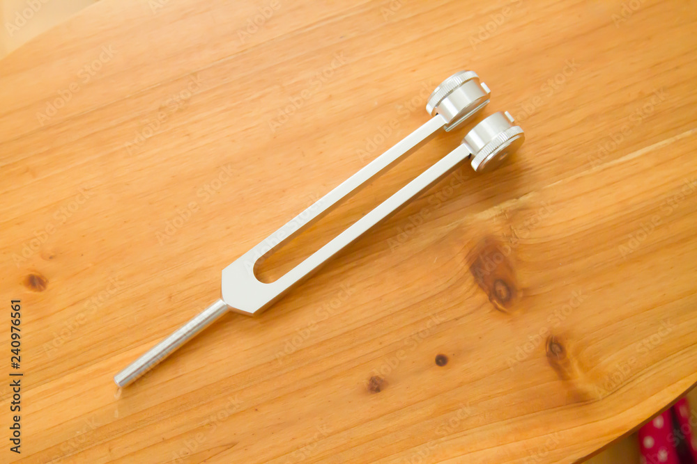 Hand holding a tuning fork . Hand holding a tuning fork .