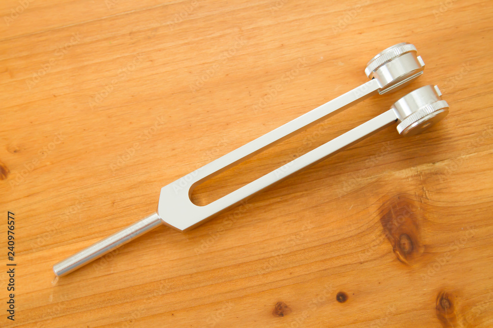 Hand holding a tuning fork . Hand holding a tuning fork .