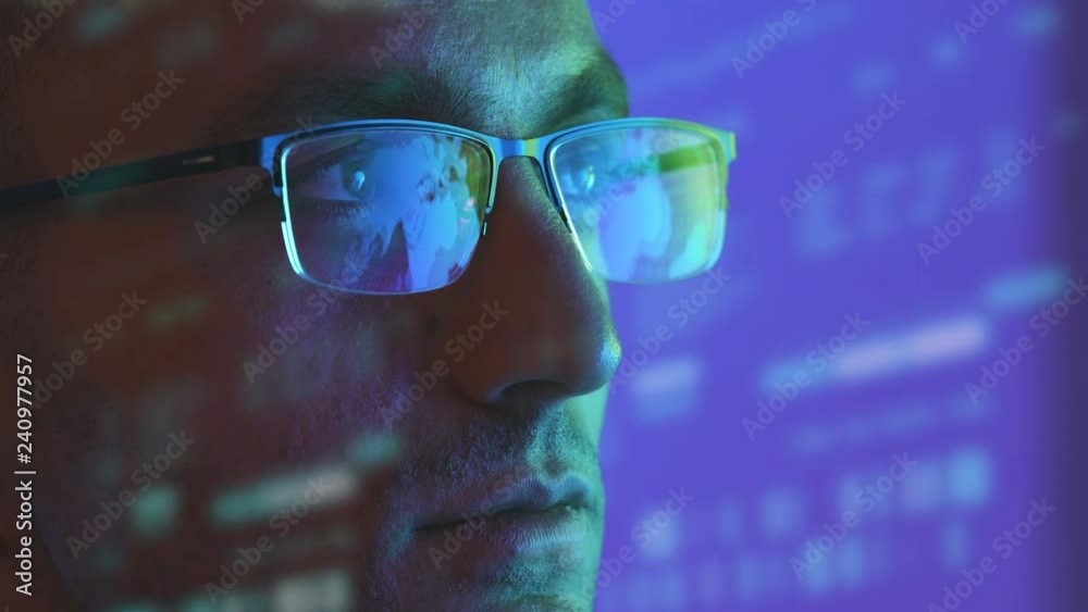 The man in glasses looking to the display on the hologram background