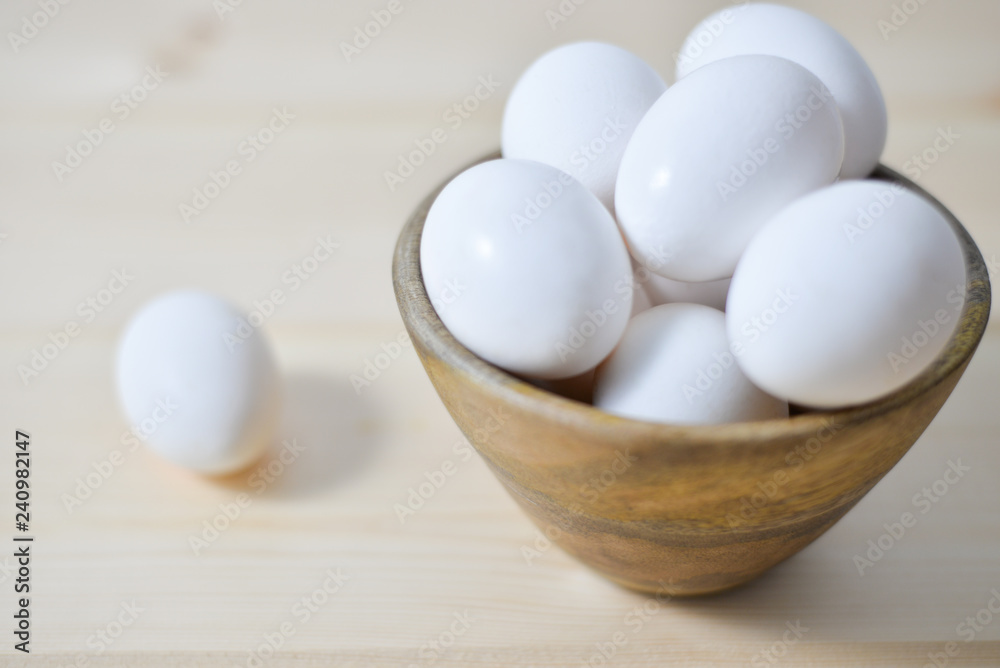 white eggs on wooden plate on wooden background , copy space white eggs on wooden plate on wooden background , copy space