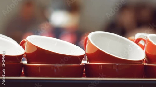 Empty red cups for espresso and for coffee and milk standing and warming up on the surface of the coffee machine