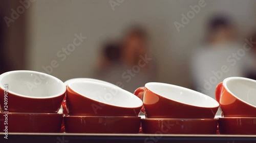 Empty red cups for espresso and for coffee and milk standing and warming up on the surface of the coffee machine