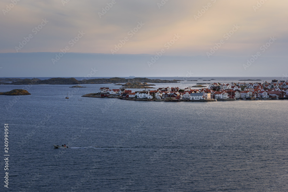 Marine landscape with coastal city on an island at sunset.