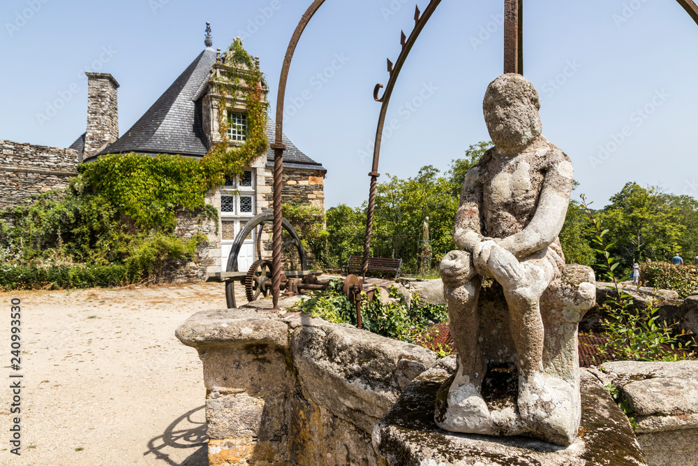 Obraz premium Rochefort-en-Terre, France. A well with a statue at Rochefort, one of the most beautiful towns in Brittany (Bretagne)