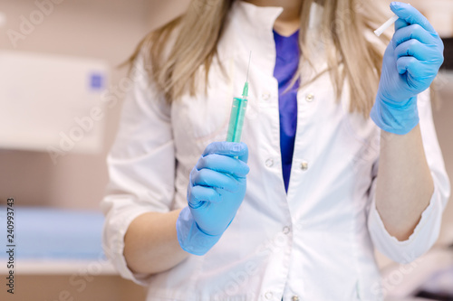 the doctor is preparing to give an injection.Doctor  female nurse or anesthetist with surgical needle giving a medical injection concept for healthcare or vaccination. selective focus