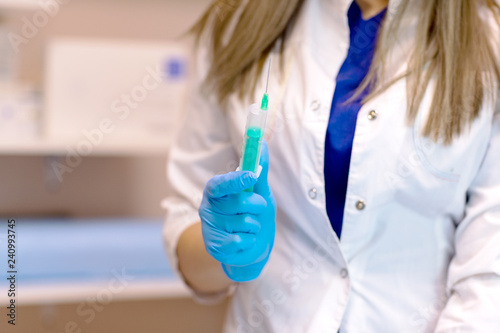 the doctor is preparing to give an injection.Doctor, female nurse or anesthetist with surgical needle giving a medical injection concept for healthcare or vaccination. selective focus