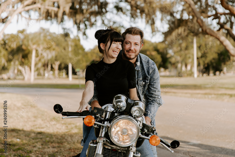 Precious Cute Leisure Lifestyle Portrait of Handsome Guy and Girl Beauty Being Silly Fun and Laughing while Riding Classic Motorcycle Bike While in Love