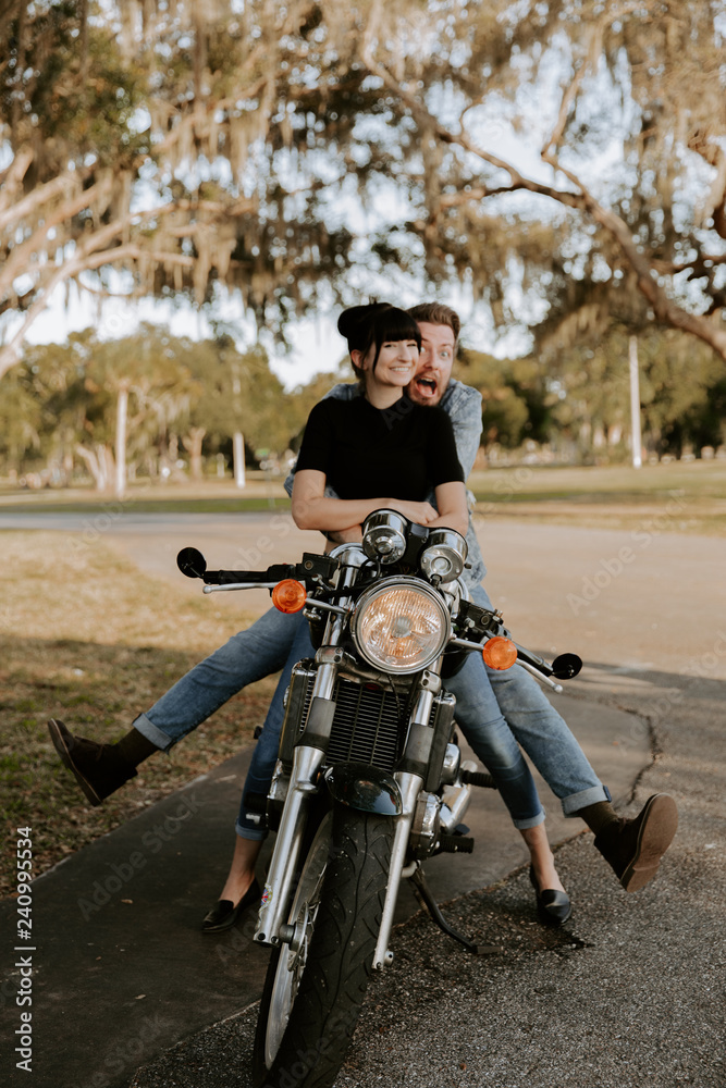 Obraz premium Precious Cute Leisure Lifestyle Portrait of Handsome Guy and Girl Beauty Being Silly Fun and Laughing while Riding Classic Motorcycle Bike While in Love