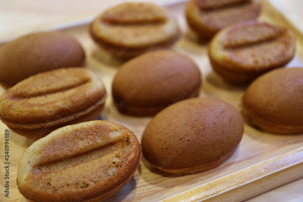 Closed Up Delectable Coffee Bean Shaped Sponge Cakes Served on Wooden Tray  