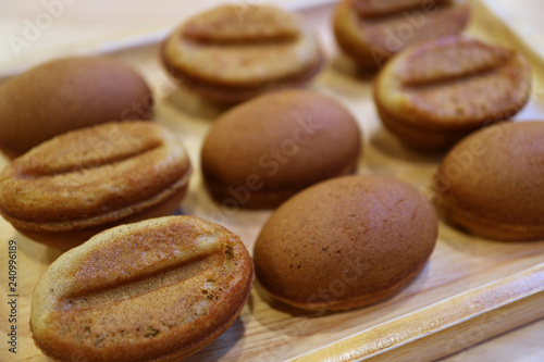 Closed Up Delectable Coffee Bean Shaped Sponge Cakes Served on Wooden Tray 