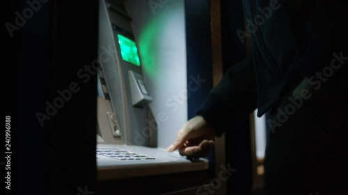 Hands of a black male using an ATM to withdraw some cash