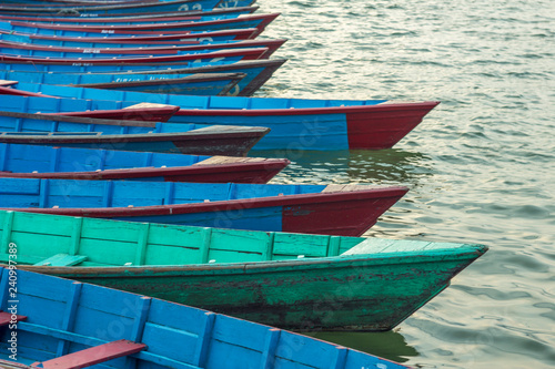 empty old wooden blue red green boats on the water stand in a row