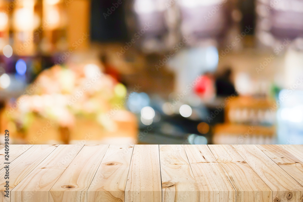 Wooden table with blur background of coffee shop.