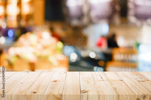 Wooden table with blur background of coffee shop.