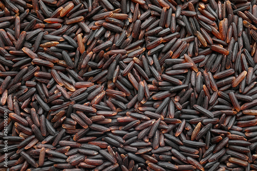 Uncooked black rice as background, top view