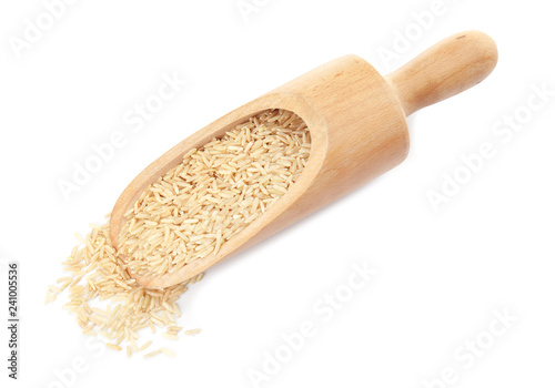 Scoop with raw unpolished rice on white background