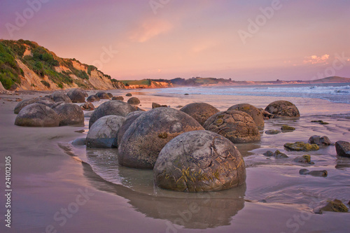 Fotografie, Obraz Sunset at th cost with famous rock formation of Moeraki Boulders, NZ