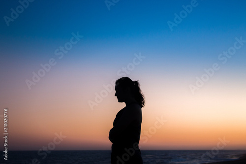 silhouette of woman at sunset © Yuri