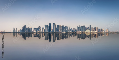 Weites Panorama der Skyline von Doha in Katar mit Reflektionen im Wasser
