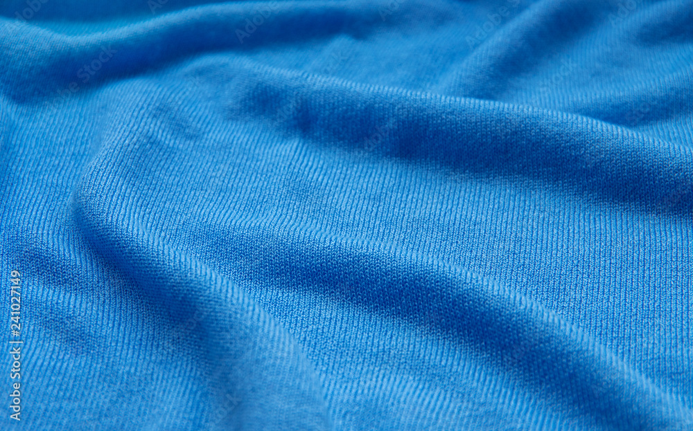 The texture of a knitted woolen fabric blue. The texture of a knitted woolen fabric blue.