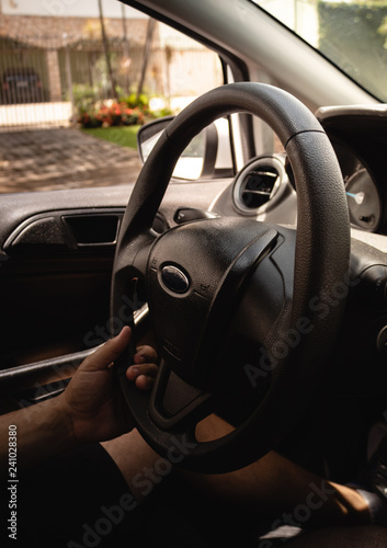 Selective focus man's hand on steering wheel, driving a car at sunset. Travel background © yan