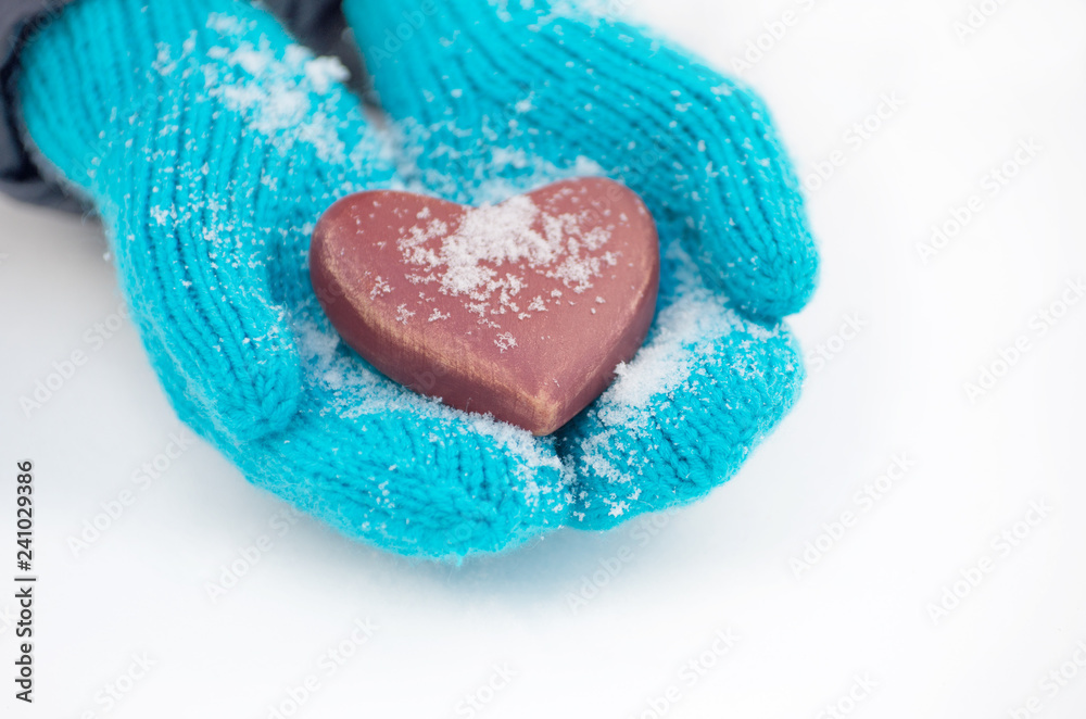 Female hands in mittens with heart, close-up Female hands in mittens with heart, close-up