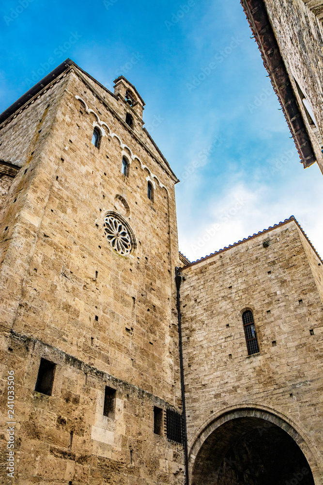 Side facade of the Cathedral Basilica of Santa Maria Annunziata, with the rose window, in Piazza Innocenzo III. Stone buildings from the Middle Ages. Anagni, Frosinone, Italy.