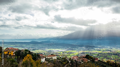 Beautiful view of the Valle del Sacco at sunset, from Anagni, Frosinone, Italy. Rays of light in the clouds, the mountains and the green valley. photo