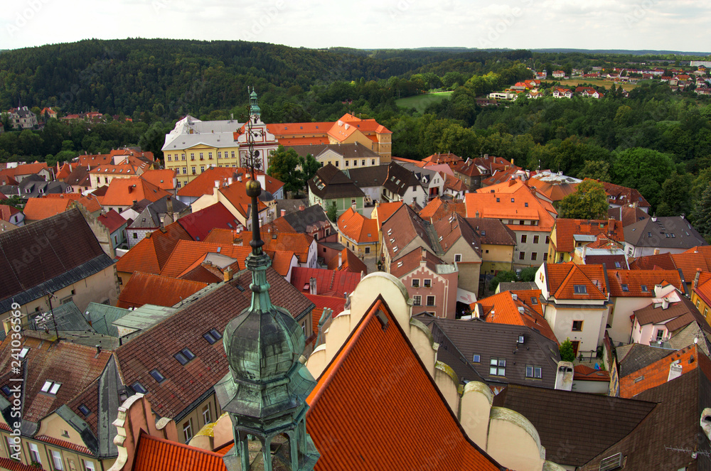 Obraz premium View from the tower in center of Tabor - summer holiday in Czech Republic. Old houses, roofs, old town, green woods, cloudy.