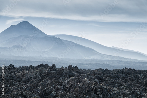 volcanic landscape with black lava field and volcano