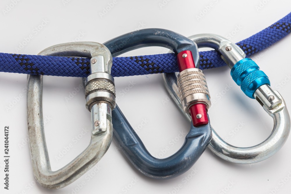 Ταπετσαρία old used metal carabines in scratches on a rope for mountaineering on white background