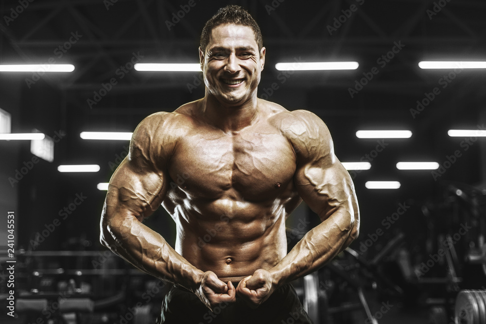 Handsome strong athletic men pumping up muscles workout bodybuilding concept background